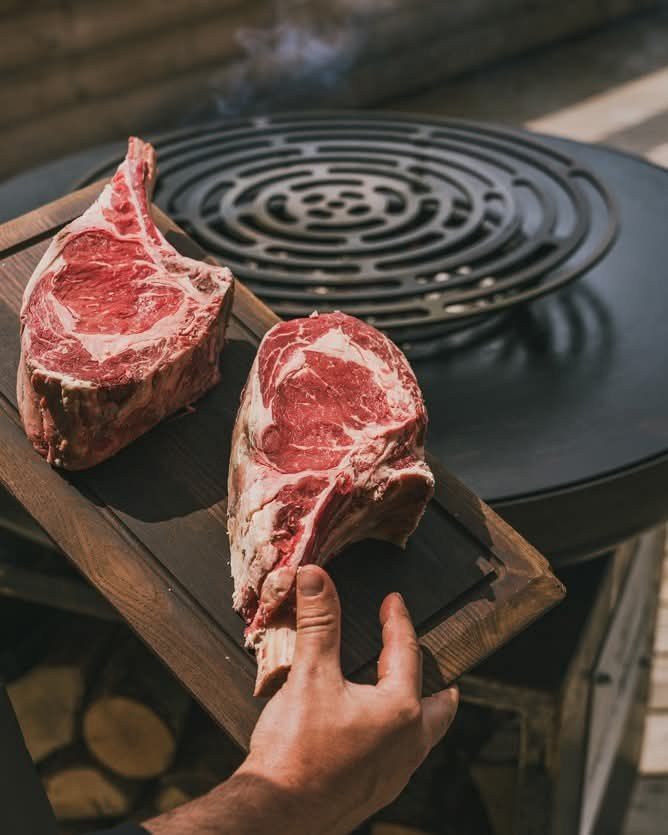Deux côtes de bœuf maturées sur une planche, près de la grille en spirale