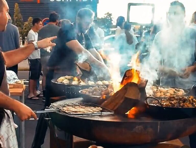 Cuisson en plein air devant la foule : braséro, bûches et grillades