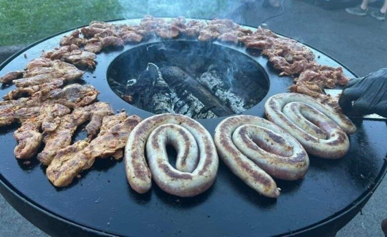 Saucisses en spirale et côtes grillées en couronne autour du foyer d'un braséro rond de 100