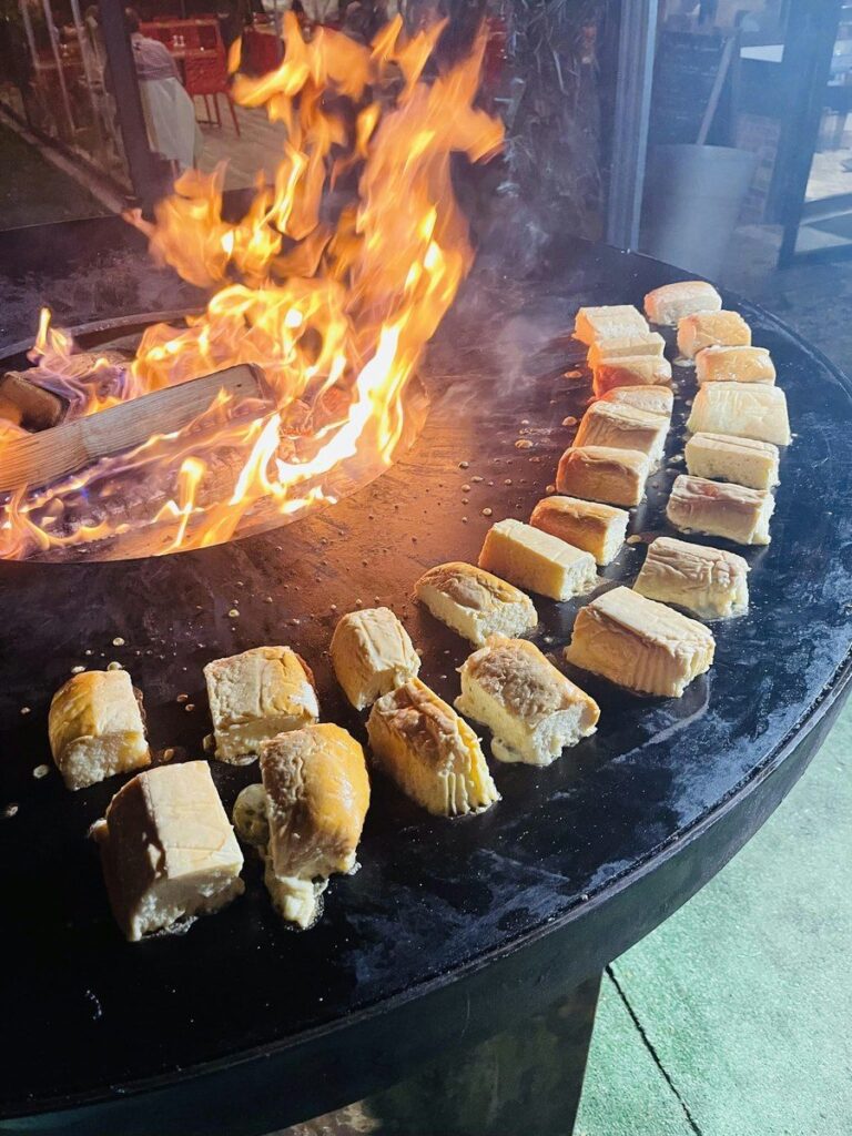 Bouchées grillées disposées en couronne autour des grandes flammes du foyer