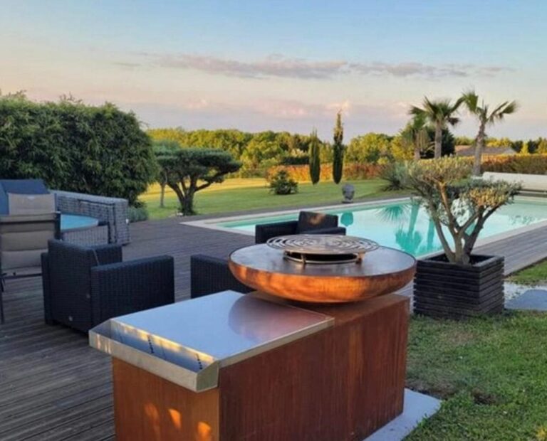 Braséro rond de 80 sur meuble en corten avec tablette inox, au bord d'une piscine