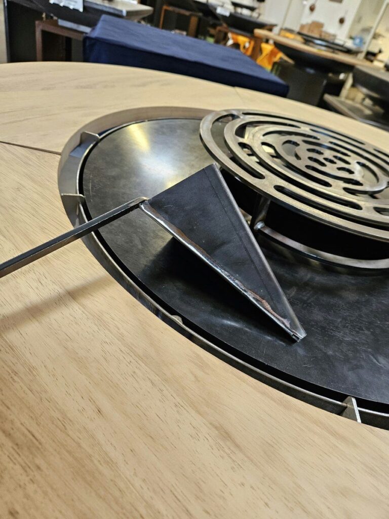 Capucin en acier posé sur la grille d'un braséro