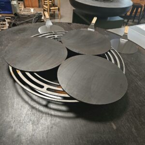 Trois crêpières en acier posées sur la grille d'un braséro de 150