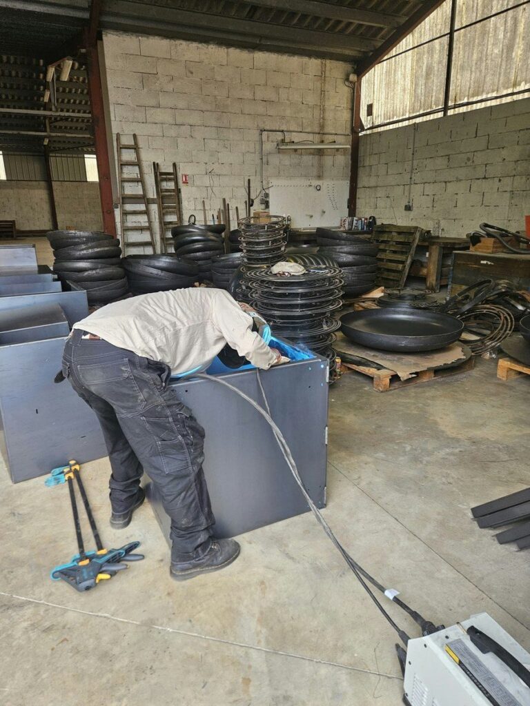 Soudeur au travail sur un caisson de braséro