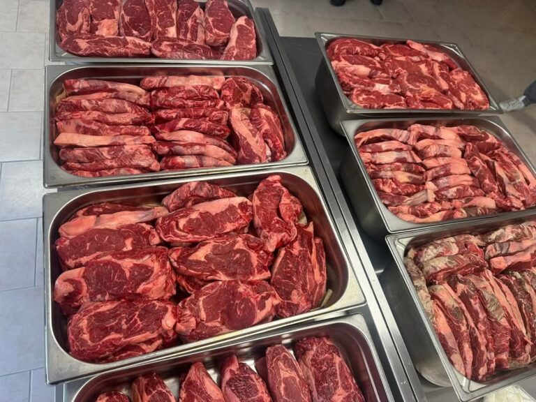 Bacs inox remplis de côtes et de pièces de bœuf prêtes à griller