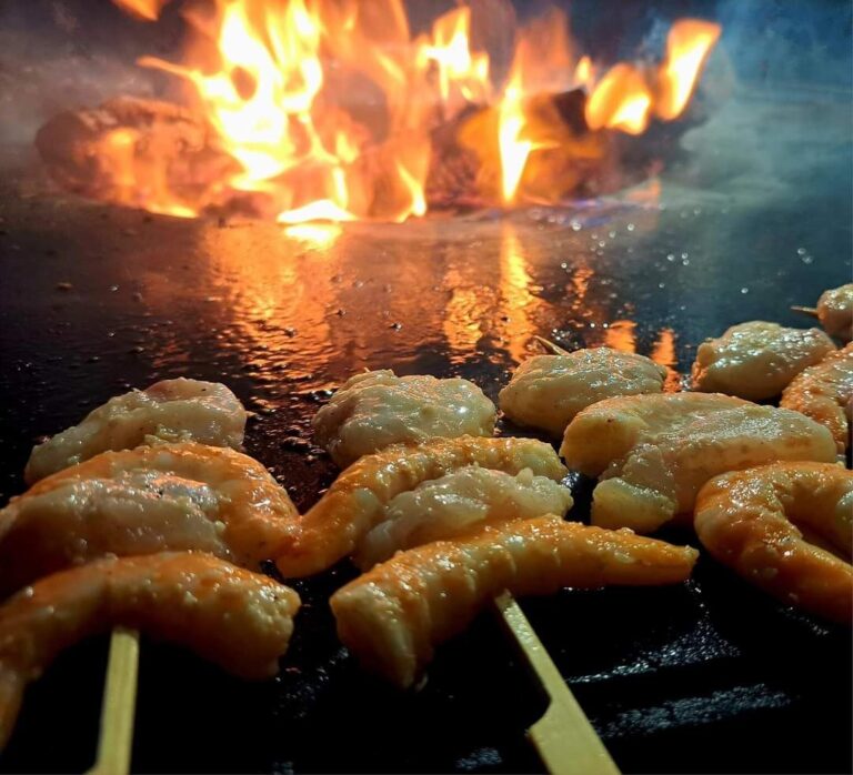 Brochettes de crevettes sur la plancha devant les flammes
