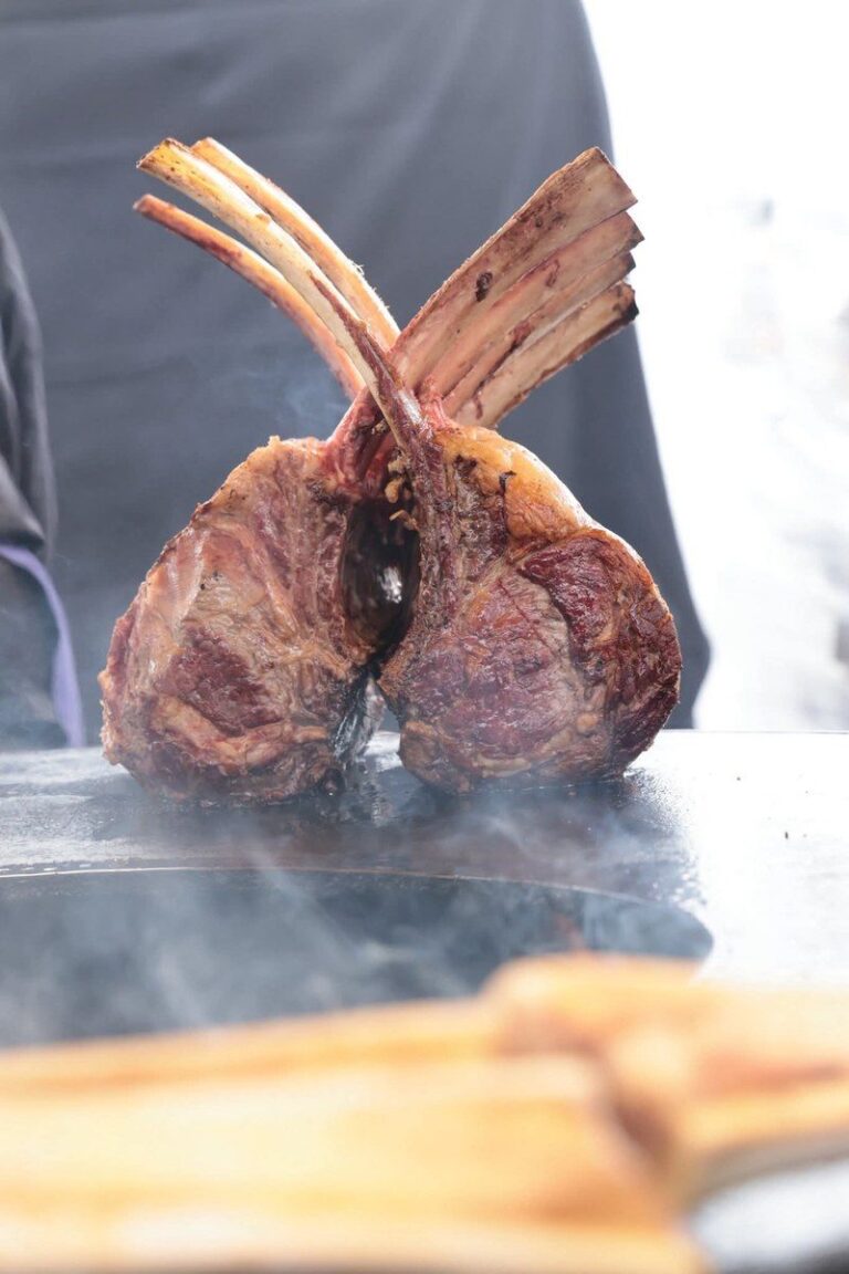 Carré de côtes de bœuf posé sur la plancha dans la fumée