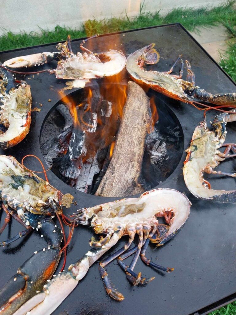 Langoustes grillées autour du foyer, sur une plancha carrée