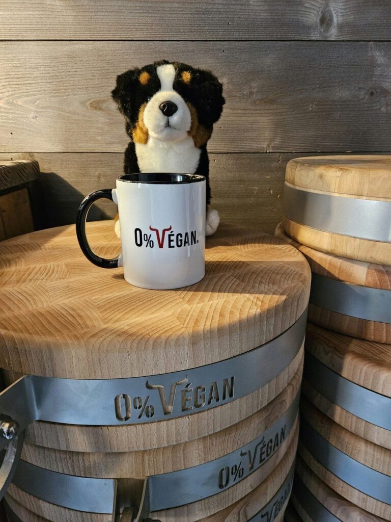 Mug 0% Végan avec une peluche de chien, posé sur un billot