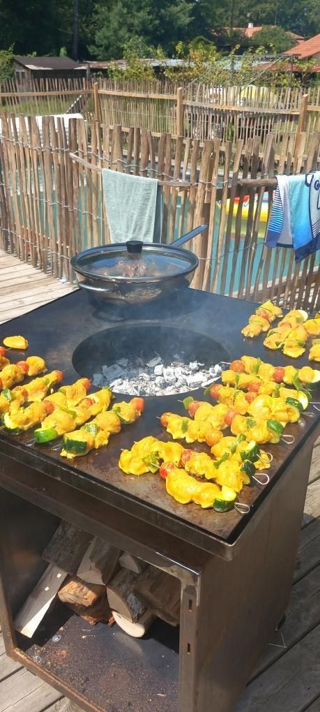 Plancha carrée en acier garnie de brochettes de poulet et de poivrons