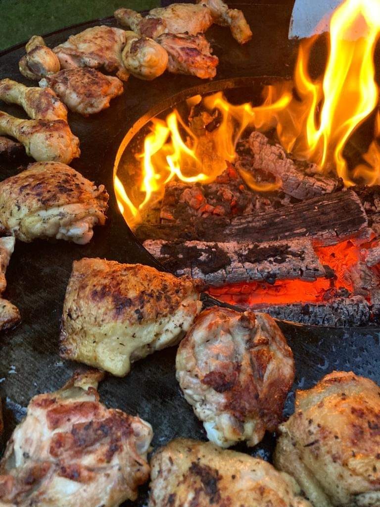 Morceaux de poulet rôtis autour des braises du foyer