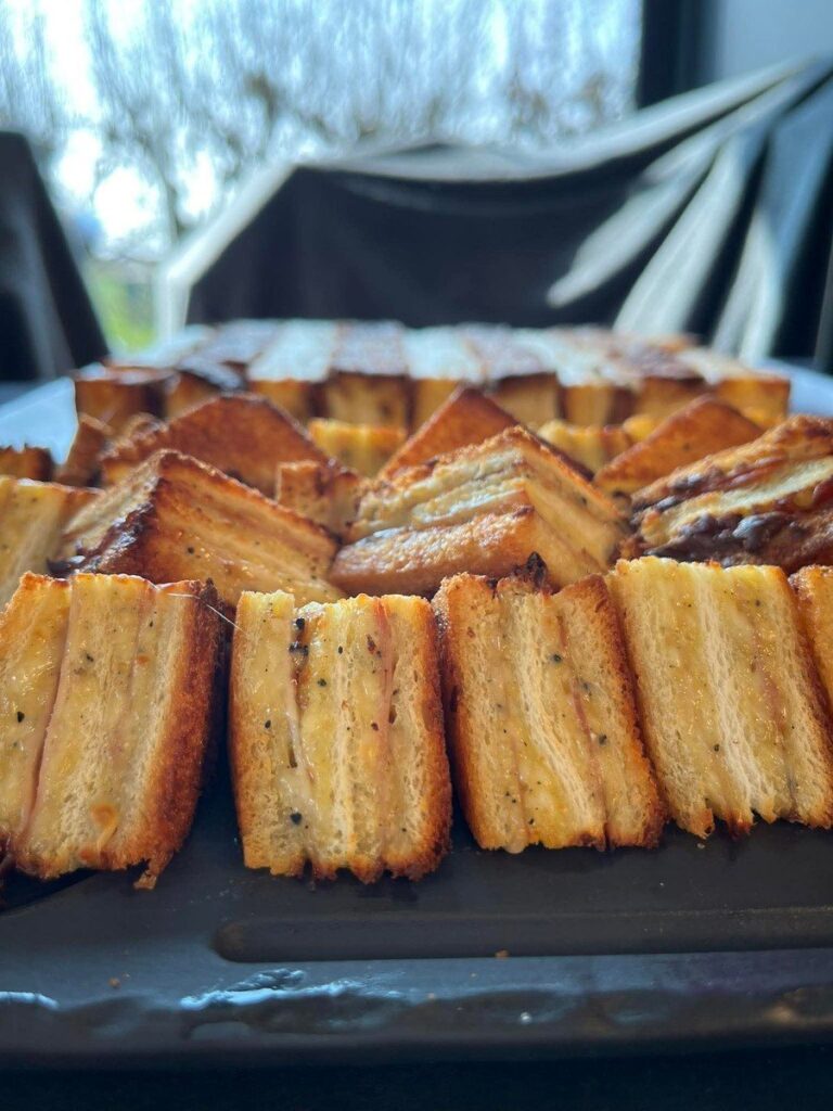 Tranches de pain grillées alignées sur la plancha d'un braséro