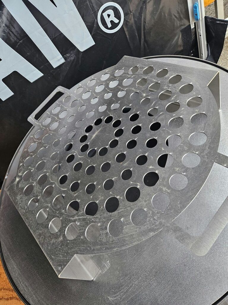 Grille à escargots en inox sur la plancha, devant la banderole 0% Végan