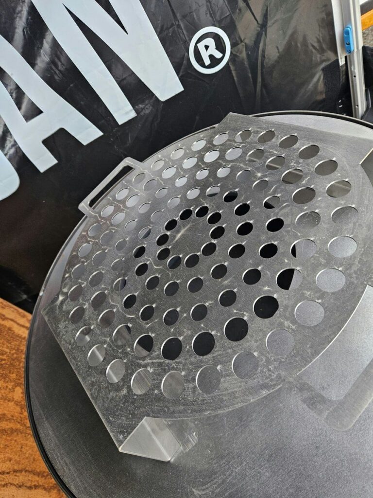 Grille à escargots en inox sur la plancha, devant la banderole 0% Végan