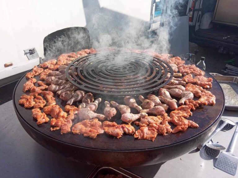 Pilons et morceaux de poulet marinés en couronne autour de la grille ronde de la plancha