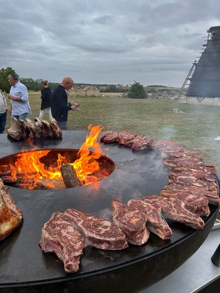 Steaks et rôtis grillant autour du foyer, braséro sur remorque