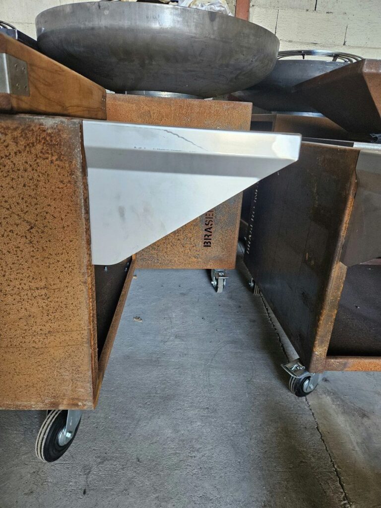 Tablette inox fixée sur le côté d'un meuble de braséro en corten